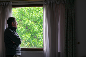 man looking out window