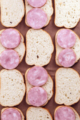 Twelve slices of sausage rolls on brown kitchen towel