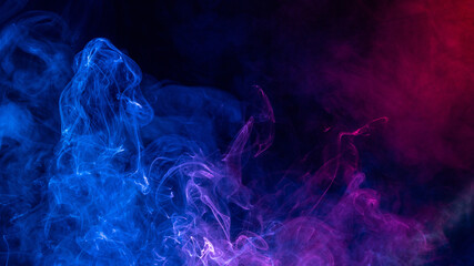 Conceptual image of colorful red and blue color smoke on dark black background.