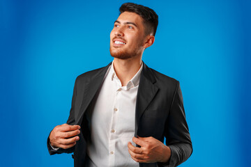 Portrait of a young mixed race businessman against blue background