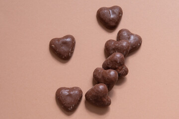 German chocolate covered gingerbread  hearts on coral colored background.  Gingerbread covered with chocolate. Christmas desert, snack.