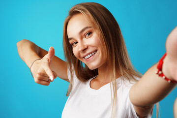 Fototapeta premium Positive young blonde woman looking at camera and pointing on you
