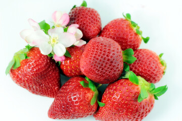 Intensive red strawberries on a white plate.