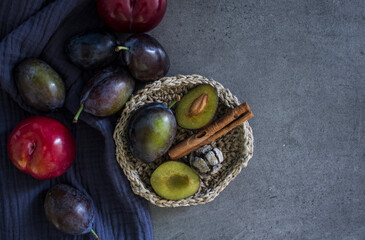 Plums on textured blue kitchen towel. Fresh summer fruits top view photo. Healthy eating concept. 