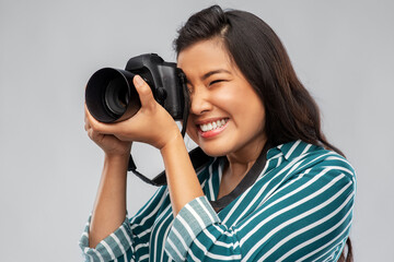 photography, profession and people and concept - happy smiling asian female photographer with digital camera