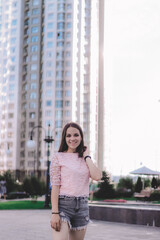 Fototapeta na wymiar girl near skyscraper, modernized house on background