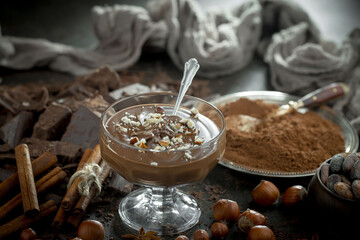 Hot chocolate on an old background in a composition with cocoa beans and nuts.