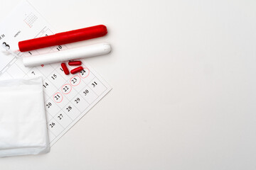 Fototapeta premium Menstruation calendar with sanitary pads and tampons, pills