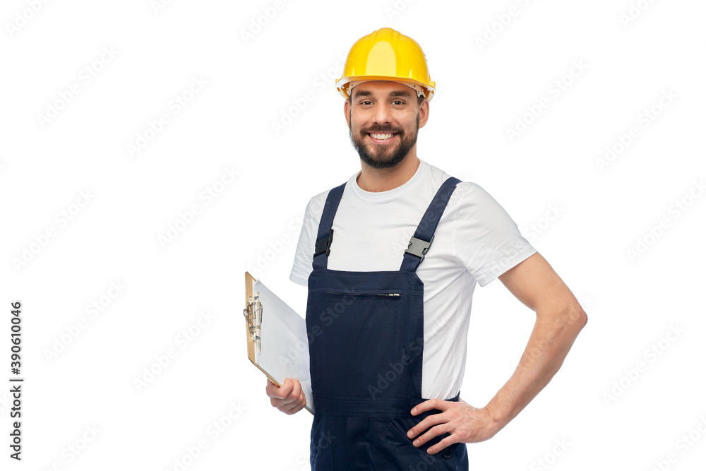 Wall mural profession, construction and building - happy smiling male worker or builder in yellow helmet and overall with clipboard over white background