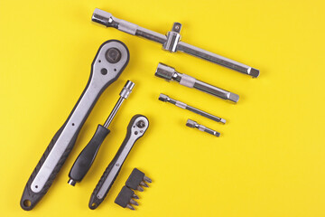 Flat lay with set of tools supplies for repair car on yellow background. Top view with copy space.