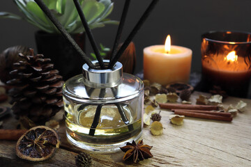 Obraz na płótnie Canvas luxury aromatic scented reed diffuser or air freshener decorated on wooden table with background of scented candle in the living room of the house during Christmas new year party celebration 
