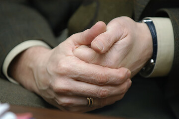Businessman tight hands sitting at the table close-up.