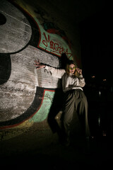 Female at night with a graffiti background. Low key