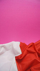 Folded Flag of Poland on Vivid Pink Background