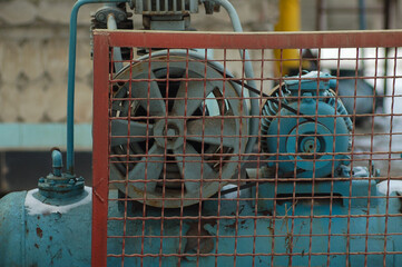 old motor driven on a large barrel with a protective mesh
