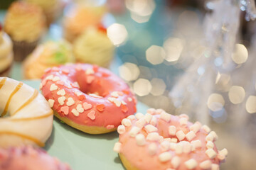 Bright donut in a pink glaze on festive background.