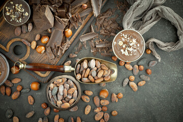 Pieces of dark chocolate and cocoa beans in composition on old background