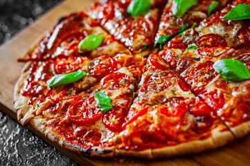 sliced Pizza with Mozzarella cheese, Tomatoes, pepper, Spices and Fresh Basil. Italian pizza. Pizza Margherita or Margarita