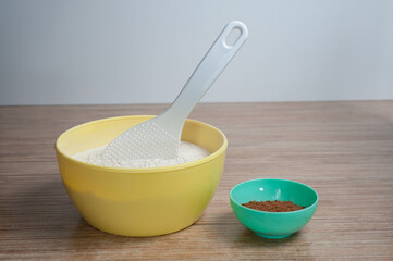 bowls of flour and cocoa are on the kitchen table