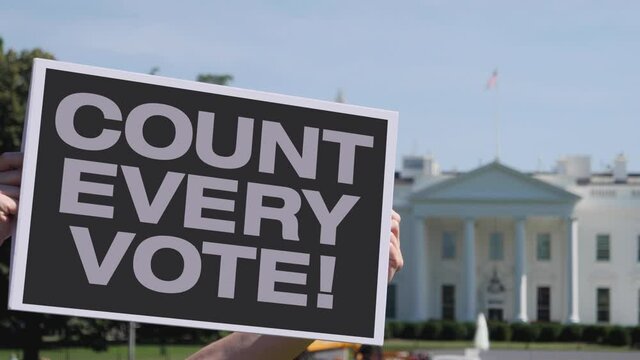A man holds a COUNT EVERY VOTE! protest sign outside the White House. Election results were in question after the 2020 presidential election.  	