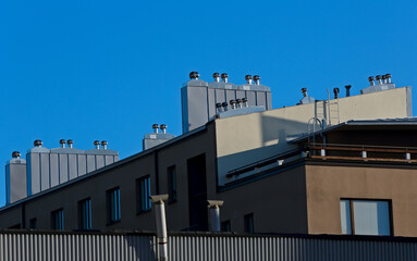 A apartment house with shiny ventilation pipes on the roof