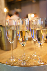 few transparent glasses with champagne on a rack in a bar or restaurant prepared for guests of festive events.
