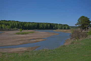 shallow river in early spring in the village of russia