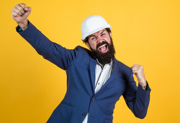 concept of engineering. architecture and building. male builder wearing formal suit and helmet for protection. working on construction project. happy man with beard wear hard hat