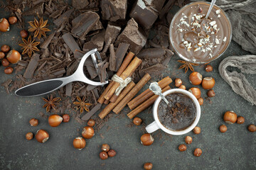 Pieces of dark chocolate and cocoa beans in composition on old background