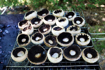 Cooking mushrooms on the grill. Champignon white mushrooms grilled on grill or BBQ