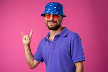 Funny bearded smiley man wearing beach hat and sunglasses