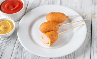 Corn dogs on white serving plate