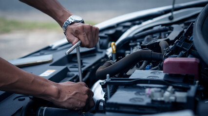 A car mechanic working in a car repair professional mechanic car maintenance service hand holding a wrench