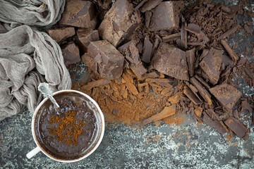 Pieces of dark chocolate and cocoa beans in composition on old background