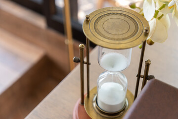 vintage bronze hourglass on table.