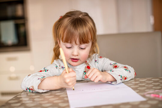 Young Girl Writing At Kitchen Table