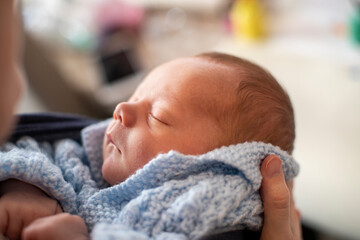 Head of sleeping baby boy being held in hands