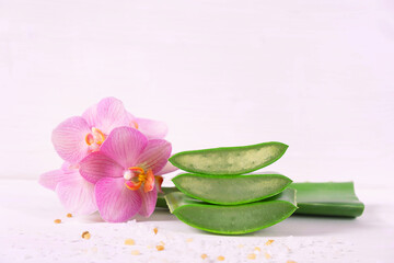 three juicy pieces of aloe vera and pink phalaenopsis orchid
