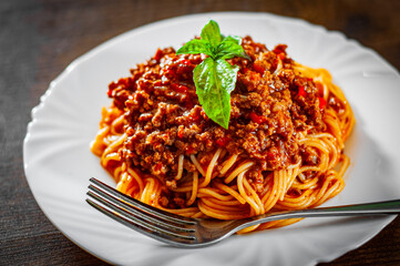 Traditional pasta spaghetti bolognese in white plate on wooden table background