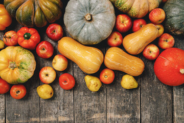Pumpkins and red apples on wooden background