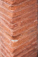 Close up of a corner of a brown brick wall. Materials. Cracks on the brick wall.