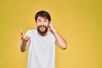 Bearded man in white t-shirt emotions close-up fun yellow background