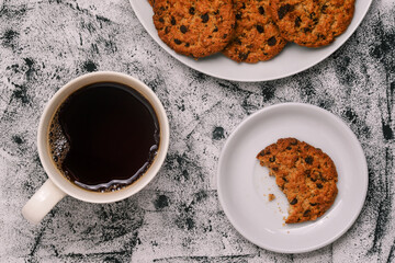 Brown biscuits, a cup of black coffee and a nibble of sweet homemade pastries. Morning breakfast, coffee break. Sweet food. Top view, flat lay