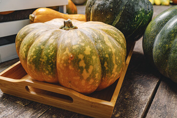 Pile of pumpkins in wooden box on wooden board