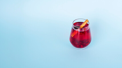 Christmas mulled red wine with spices on blue background. Cranberry drink with cinnamon and anise. Minimalism, copy space for text