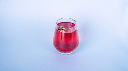 Christmas mulled red wine with spices on blue background. Cranberry drink with cinnamon and anise. Minimalism, copy space for text