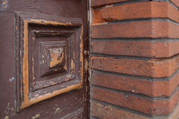 Close up on intersection of a wooden door and brick wall. Materials for the exterior walls. Building materials. Wood and brick.