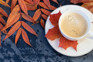 cup of coffee, autumn, bright leaves on a black table. Concept of autumn, relaxation.