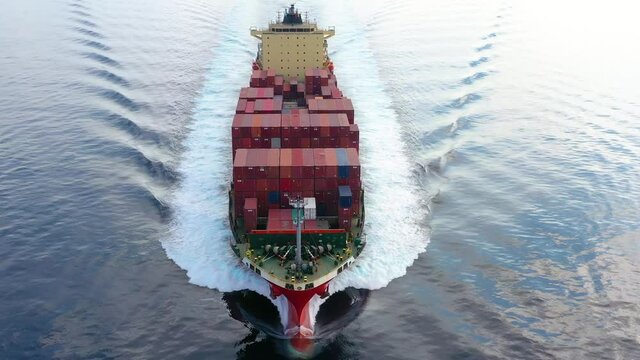 Luftaufnahme eines Container Frachter Schiffes in voller Fahrt &uuml;ber ruhigem Ozean