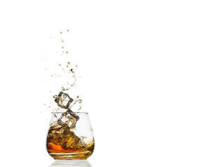 A glass of cognac with splashes from the ice cube isolated on white. alcohol splashes. whisky or...